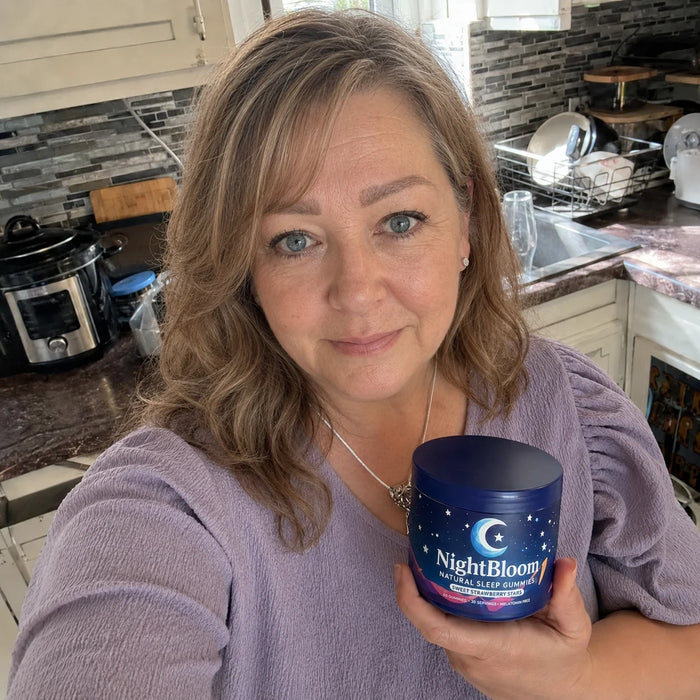 A NightBloom customer with her jar of sleep gummies in her kitchen
